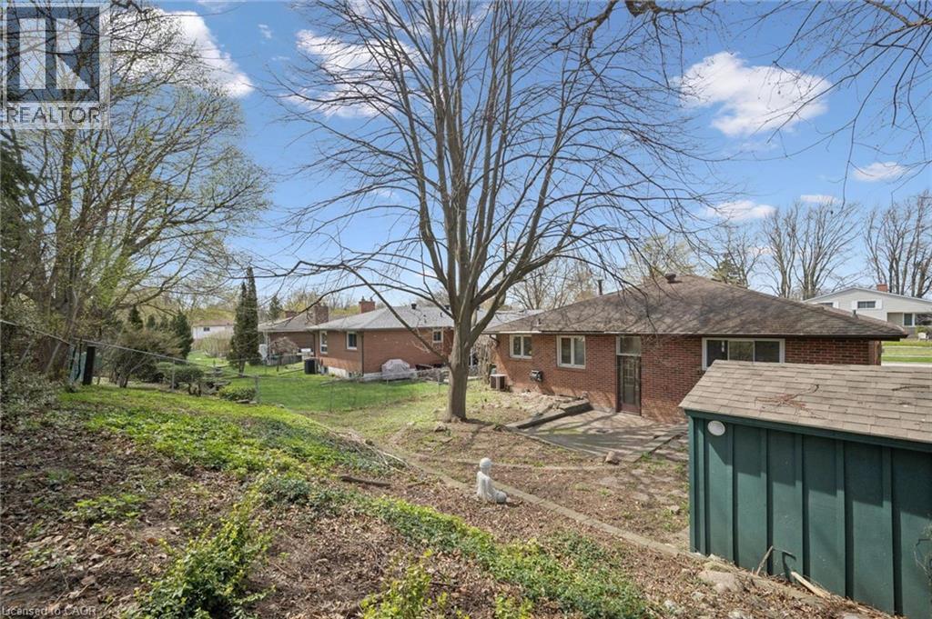 Expansive backyard featuring a sloped lawn and mature trees - 27 Silverspring Crescent, Kitchener, ON - Outdoor