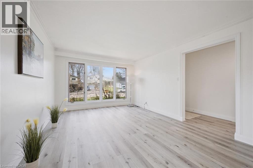 Bright interior space featuring light wood-finish flooring, white walls, and extensive crown molding - 27 Silverspring Crescent, Kitchener, ON - Indoor