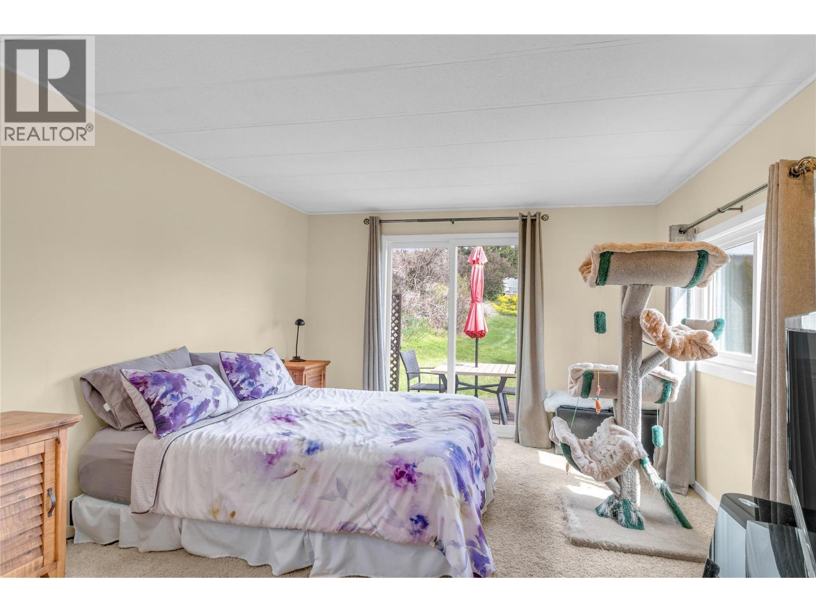 Primary bedroom. So bright with the sliding glass door leading to a cute deck and backyard. - 12022 Pretty Road Unit# 16, Lake Country, BC