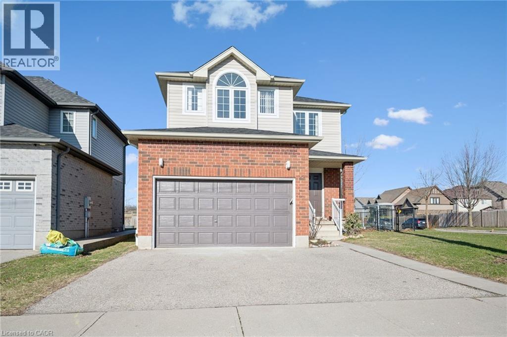 View of front of property featuring brick siding, asphalt driveway, a garage, a porch, and a residential view - 649 Doon South Drive, Kitchener, ON - Outdoor