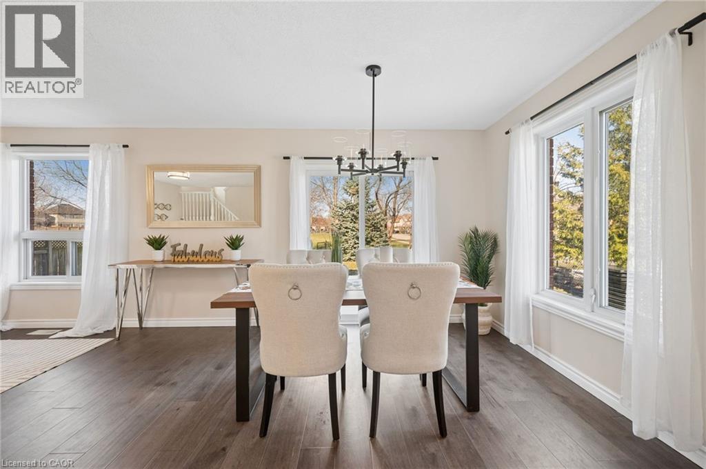 Dining space with dark wood-type flooring and hanging lights - 649 Doon South Drive, Kitchener, ON - Indoor Photo Showing Dining Room