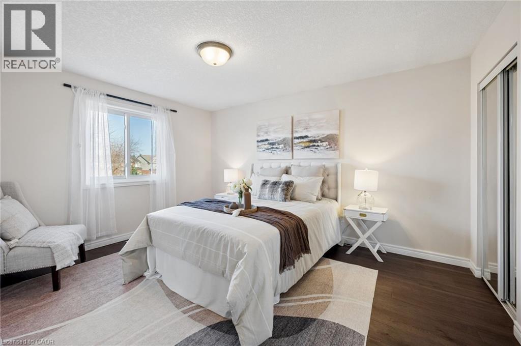 Bedroom featuring dark wood-type flooring, a textured ceiling, and a closet - 649 Doon South Drive, Kitchener, ON - Indoor Photo Showing Bedroom