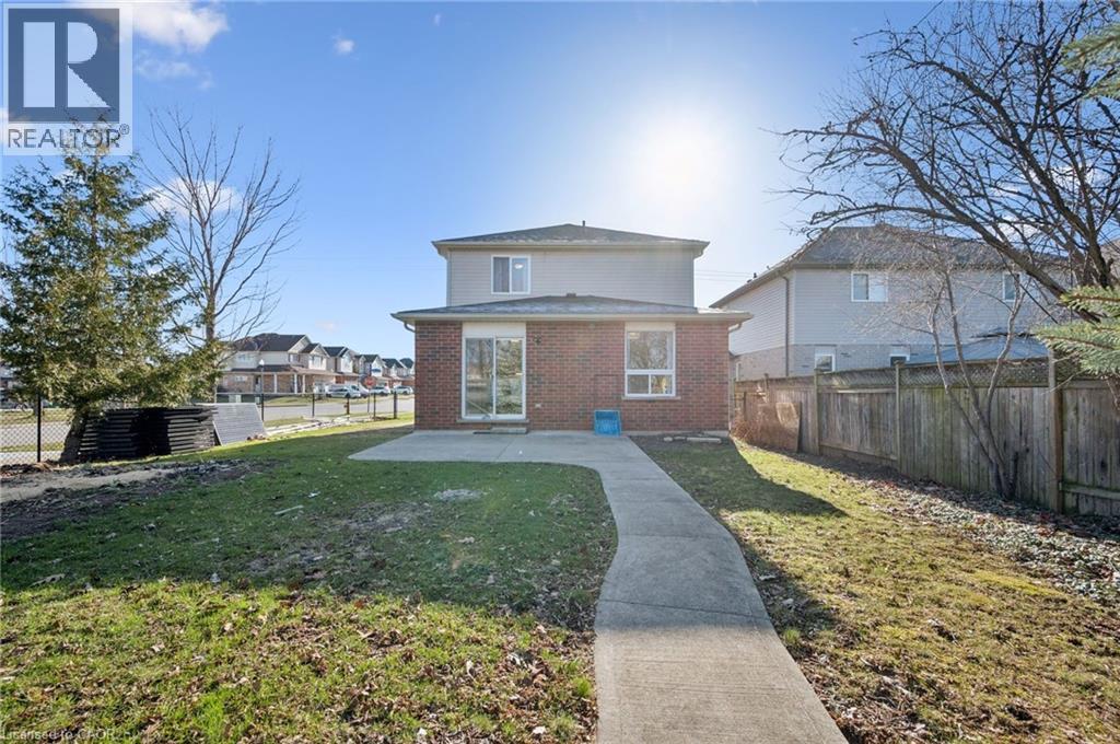 Rear view of house with brick siding, a fenced backyard, a patio area, and a residential view - 649 Doon South Drive, Kitchener, ON - Outdoor