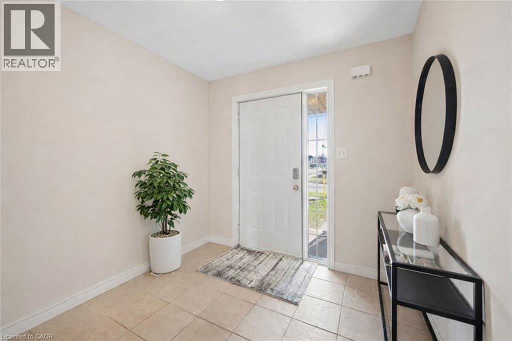 Entrance foyer with baseboards and light tile patterned floors - 649 Doon South Drive, Kitchener, ON - Indoor Photo Showing Other Room
