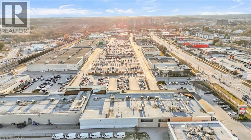 Expansive commercial property featuring multiple interconnected buildings, extensive surface parking areas, and convenient roadway frontage - 589 Fairway Road S, Kitchener, ON