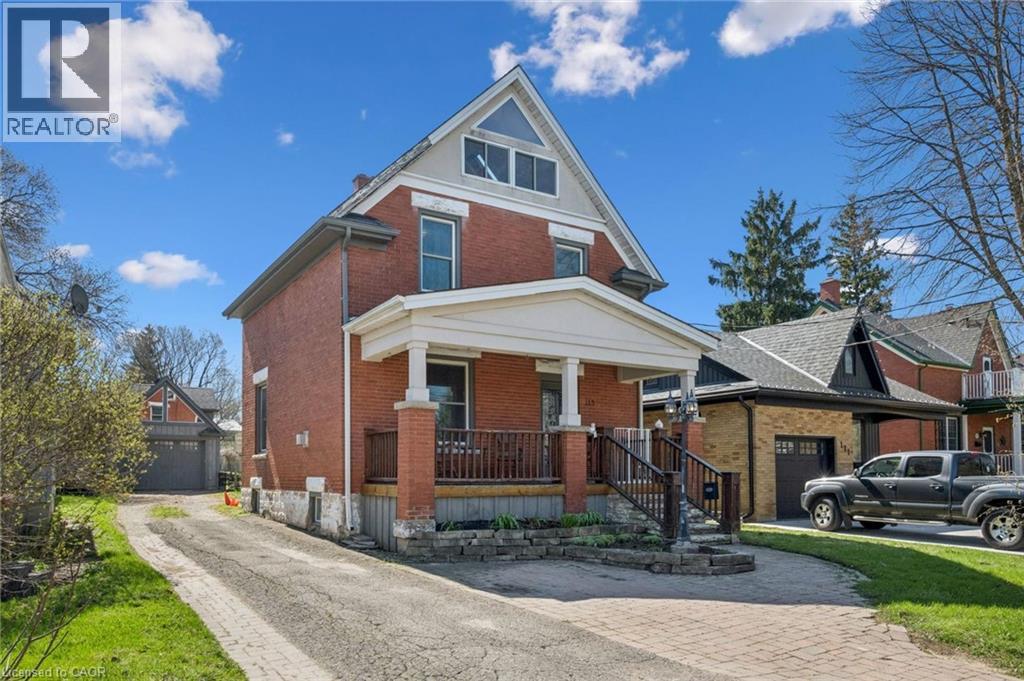 Brick exterior featuring a covered front porch with pillars, a gabled roofline, and multiple window styles - 115 Allen Street E, Waterloo, ON - Outdoor With Facade