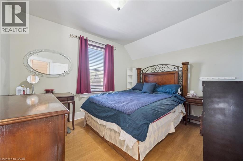 Bright room featuring wood-finish flooring, a window with blinds, and light-toned walls - 115 Allen Street E, Waterloo, ON - Indoor Photo Showing Bedroom