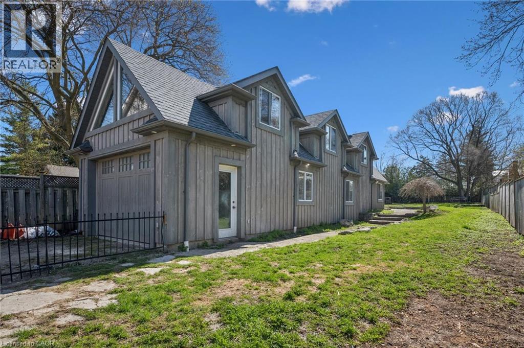 Two-story detached structure featuring vertical plank siding, multiple dormer windows, and a prominent A-frame roofline with an upper-level window - 115 Allen Street E, Waterloo, ON - Outdoor