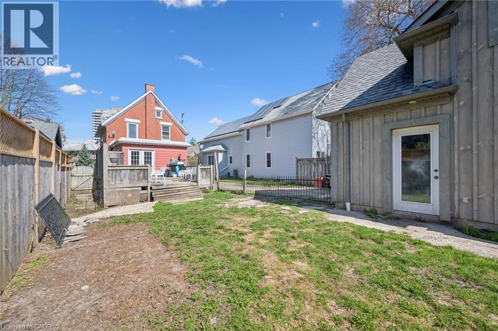 Rear exterior featuring a spacious wooden deck with railings, offering direct access to the interior via double glass doors - 115 Allen Street E, Waterloo, ON - Outdoor With Exterior