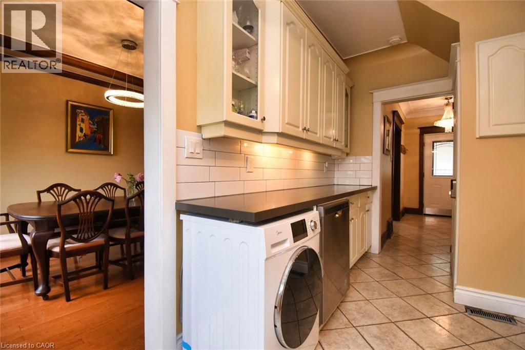 Utility area featuring a built-in washer, under-cabinet lighting, and white subway tile backsplash - 522 Aberdeen Avenue, Hamilton, ON - Indoor Photo Showing Laundry Room