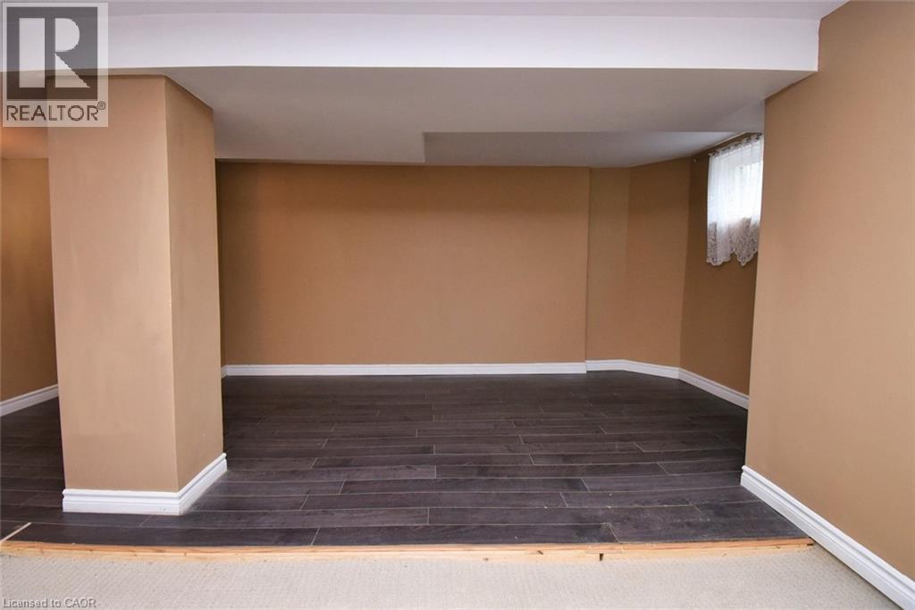Spacious room featuring dark wood-finish flooring, light tan walls, and white trim - 522 Aberdeen Avenue, Hamilton, ON - Indoor Photo Showing Other Room