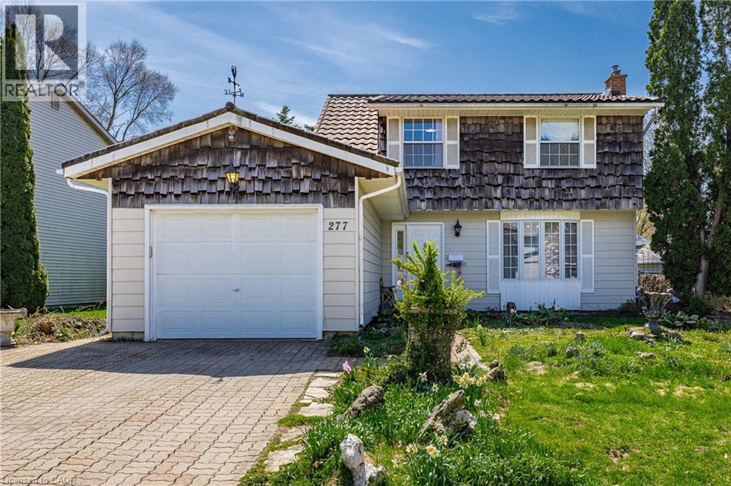 Two-story residence featuring a shingle and siding exterior, a front-facing garage with a paver driveway, and a partially landscaped front yard - 277 Blackacres Boulevard, London, ON - Outdoor