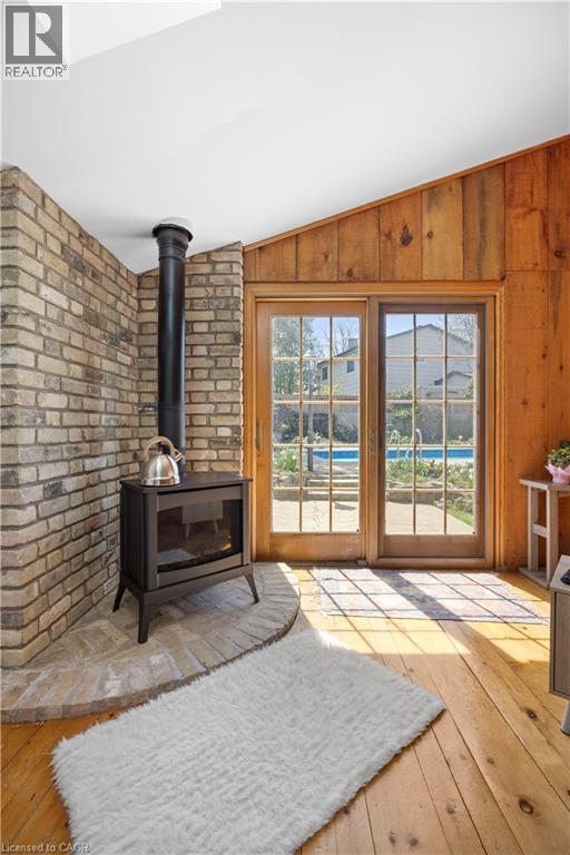 Wood-finish flooring with a brick-surround gas fireplace and a brick hearth - 277 Blackacres Boulevard, London, ON - Indoor
