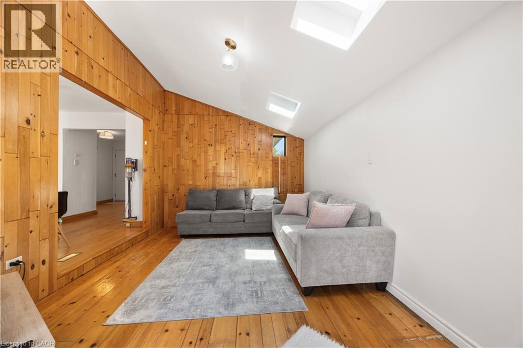 Living area featuring wood-finish flooring and a wood-paneled accent wall - 277 Blackacres Boulevard, London, ON - Indoor