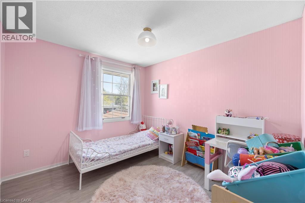 Bright room featuring wood-finish flooring, a white ceiling, and a prominent window with white trim - 277 Blackacres Boulevard, London, ON - Indoor Photo Showing Bedroom