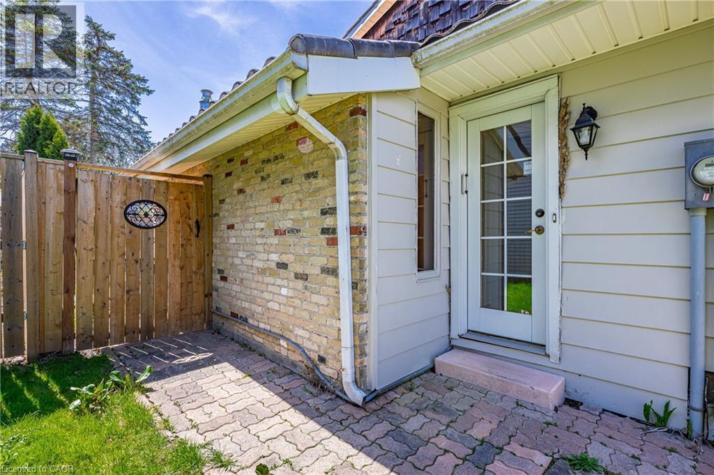 Side patio area featuring brick pavers and a wood privacy fence with decorative insert - 277 Blackacres Boulevard, London, ON - Outdoor With Exterior
