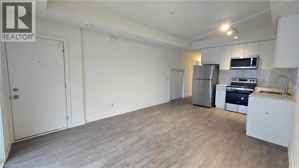 Open concept living space featuring wood-finish flooring - 16 Melbourne Avenue Unit# 210B, St. Catharines, ON - Indoor Photo Showing Kitchen With Stainless Steel Kitchen