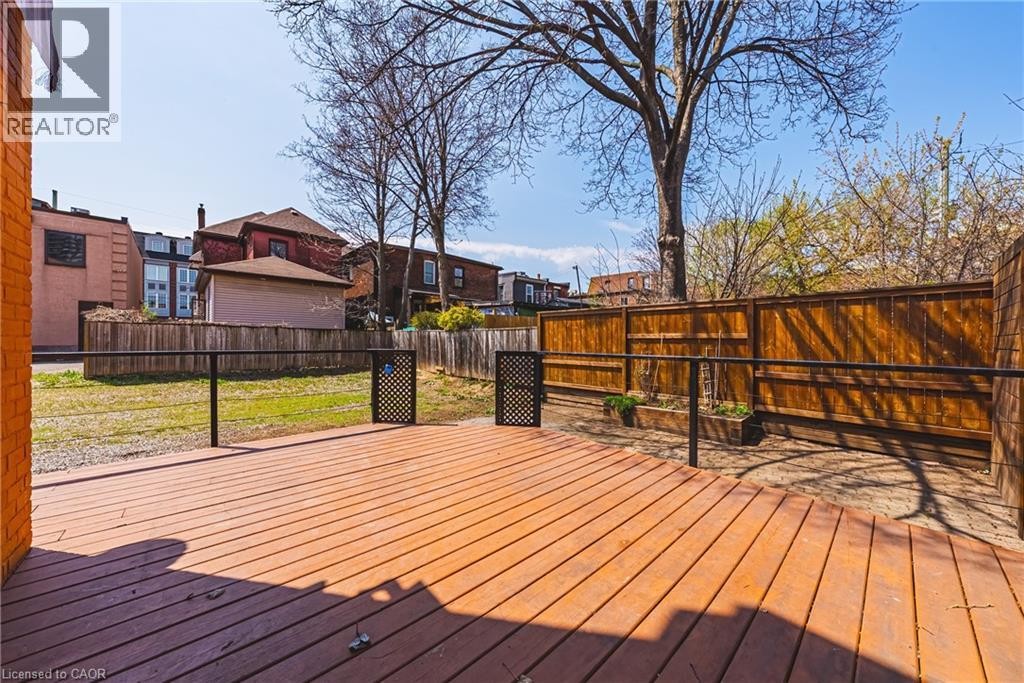 Expansive outdoor deck featuring wood decking, black metal railings, and a privacy fence - 116 Catharine Street S, Hamilton, ON - Outdoor With Deck Patio Veranda