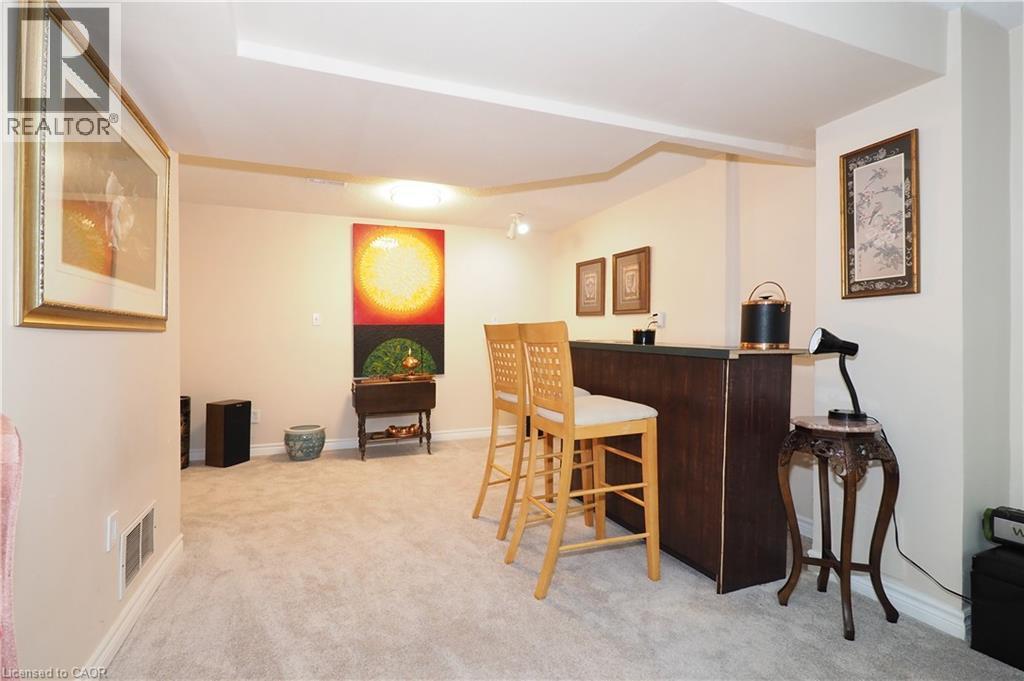 Indoor dry bar featuring light colored carpet and dark countertops - 89 Lynnhaven Court, Kitchener, ON - Indoor