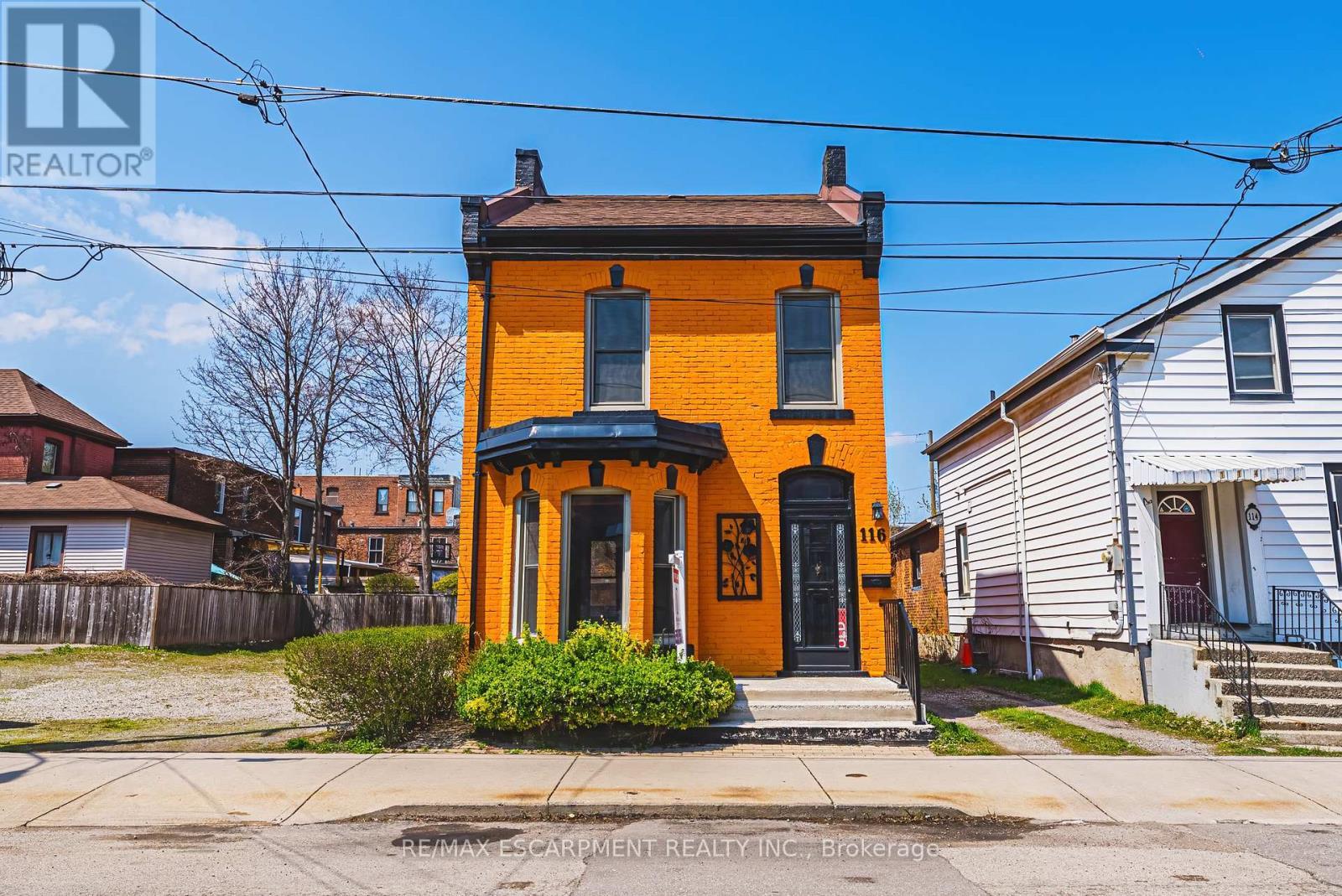 Vibrant orange brick facade w/black trim detailing - 116 Catharine Street S, Hamilton, ON