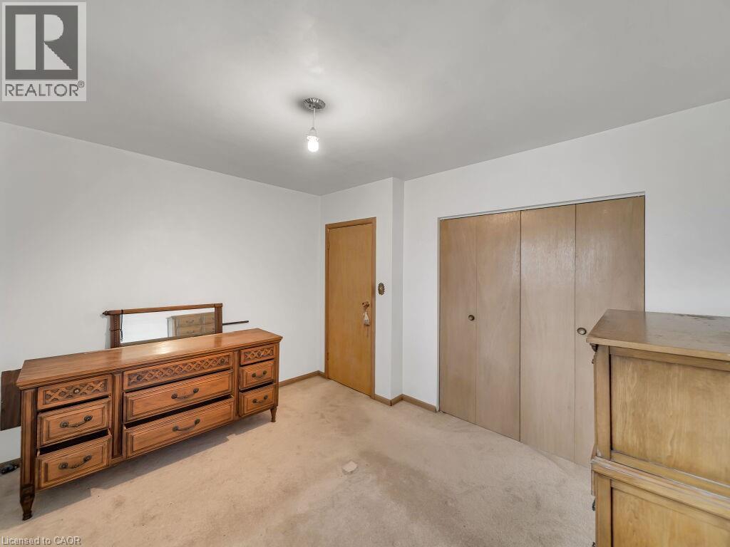 Neutral wall finishes with a ceiling-mounted light fixture, wood-finish interior door, and dual wood-finish closet doors - 1416 Highway 6, Hamilton, ON - Indoor