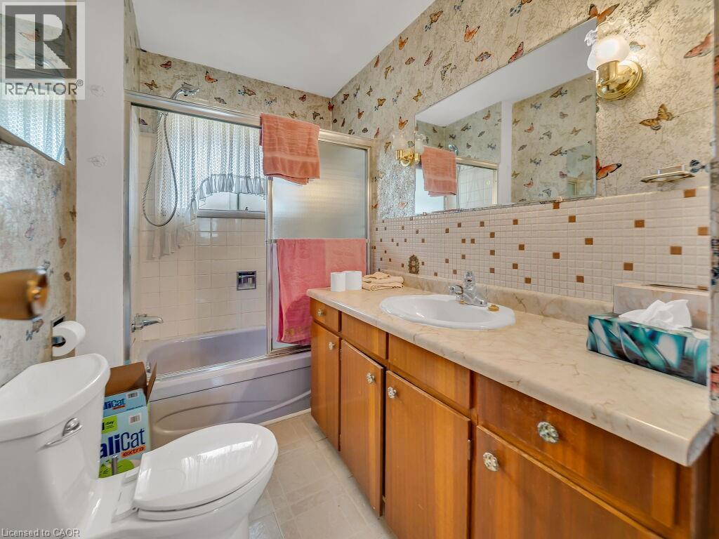 Bathroom featuring a built-in vanity with a cream-toned countertop, wood-finish cabinetry, and an integrated sink basin - 1416 Highway 6, Hamilton, ON - Indoor Photo Showing Bathroom