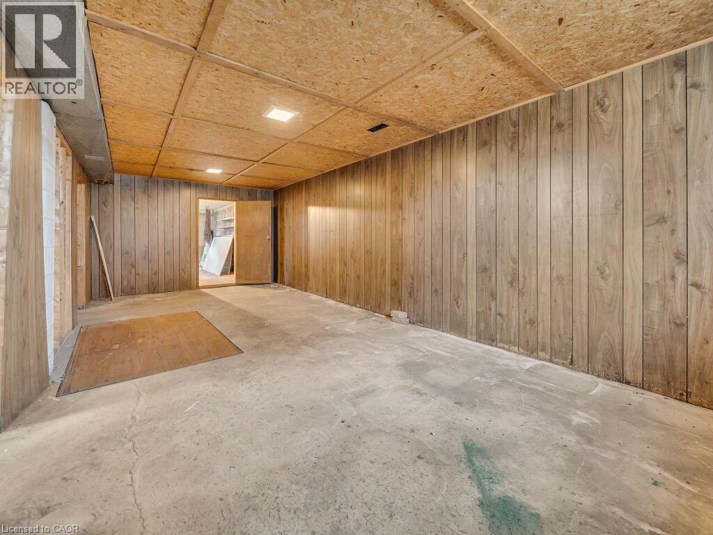 Room featuring wood-paneled walls, a concrete floor, and an exposed ceiling with recessed lighting - 1416 Highway 6, Hamilton, ON - Indoor