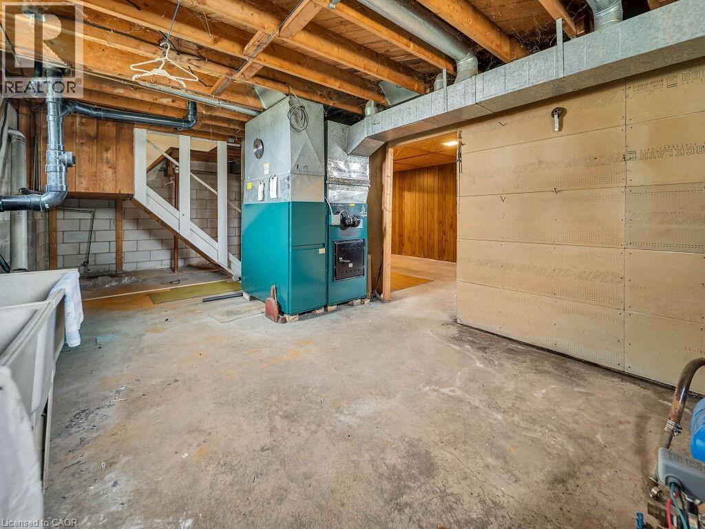 Utility space featuring a furnace, exposed ceiling joists, and concrete flooring - 1416 Highway 6, Hamilton, ON - Indoor Photo Showing Basement