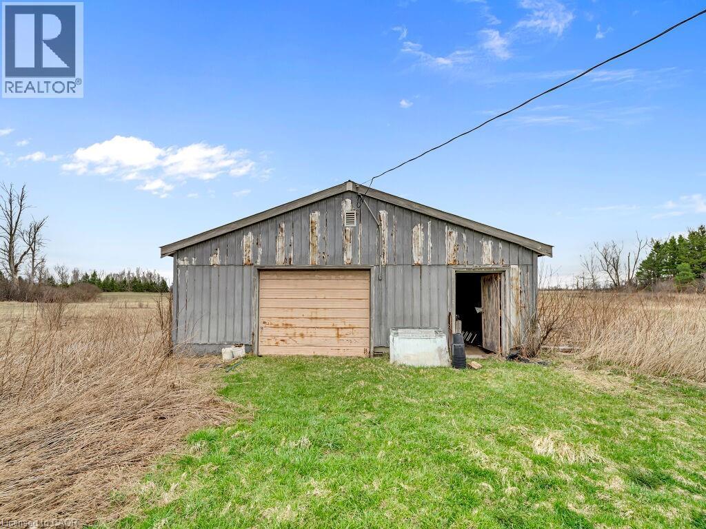 Utility building with a gable roof, roll-up door, and an additional side entrance - 1416 Highway 6, Hamilton, ON - Outdoor