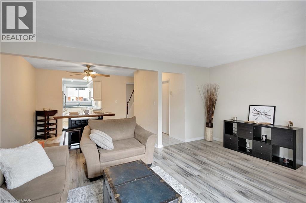 Open-concept living space featuring wood-finish flooring, neutral wall tones, and overhead lighting - 32 Montclair Crescent, Simcoe, ON - Indoor Photo Showing Living Room