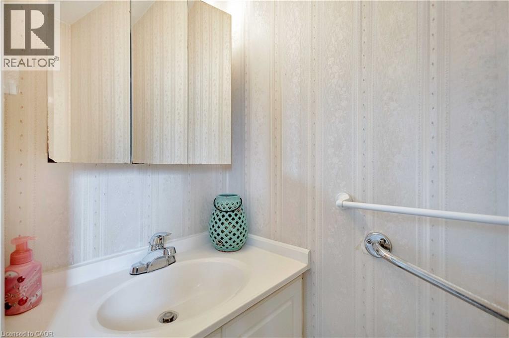 Bathroom vanity with an integrated sink, polished chrome faucet, and a wall-mounted medicine cabinet - 32 Montclair Crescent, Simcoe, ON - Indoor Photo Showing Bathroom