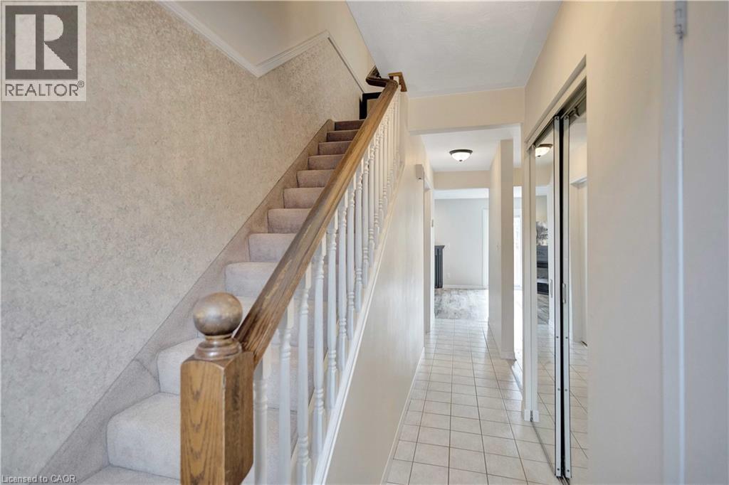 Carpeted staircase with wooden handrail and white balusters - 32 Montclair Crescent, Simcoe, ON - Indoor Photo Showing Other Room