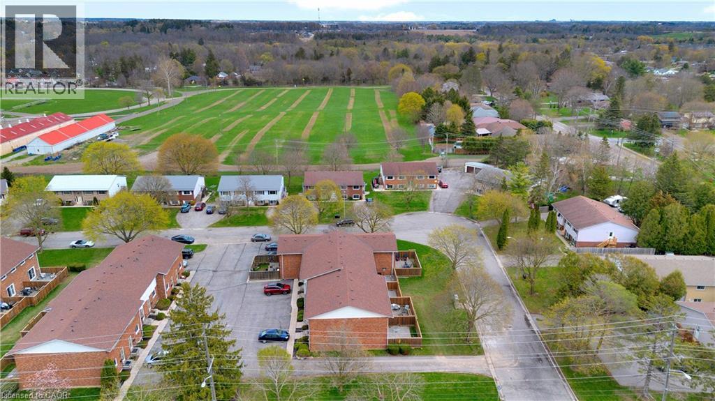 Aerial perspective highlighting multiple residential buildings with brick exteriors and shingle roofs - 32 Montclair Crescent, Simcoe, ON - Outdoor With View