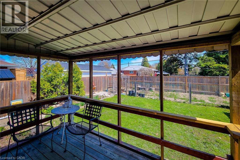 Screened-in porch featuring a wood deck, wood railings, and a metal paneled ceiling - 103 East 45Th Street, Hamilton, ON - Outdoor