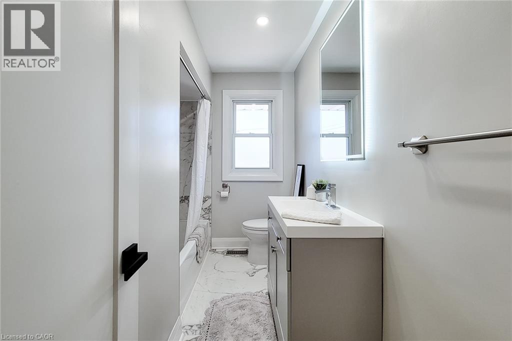 Modern bathroom featuring a contemporary vanity with a white countertop and gray cabinetry - 103 East 45Th Street, Hamilton, ON - Indoor Photo Showing Bathroom