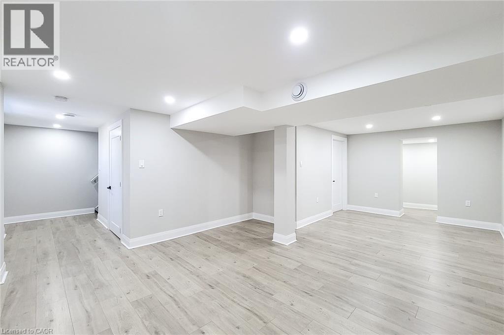 Spacious lower level featuring wood-finish flooring, recessed lighting, neutral wall tones, white trim, and architectural columns - 103 East 45Th Street, Hamilton, ON - Indoor
