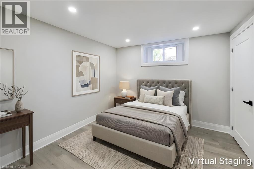 Wood-finish flooring with white baseboards, recessed lighting, and a white window frame with a single window - 103 East 45Th Street, Hamilton, ON - Indoor Photo Showing Bedroom