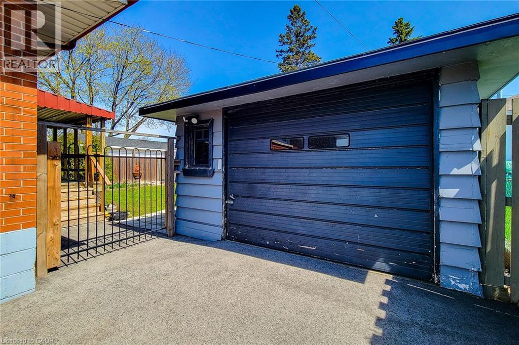 Attached single-car garage featuring a dark panel door with rectangular window inserts - 103 East 45Th Street, Hamilton, ON - Outdoor With Exterior