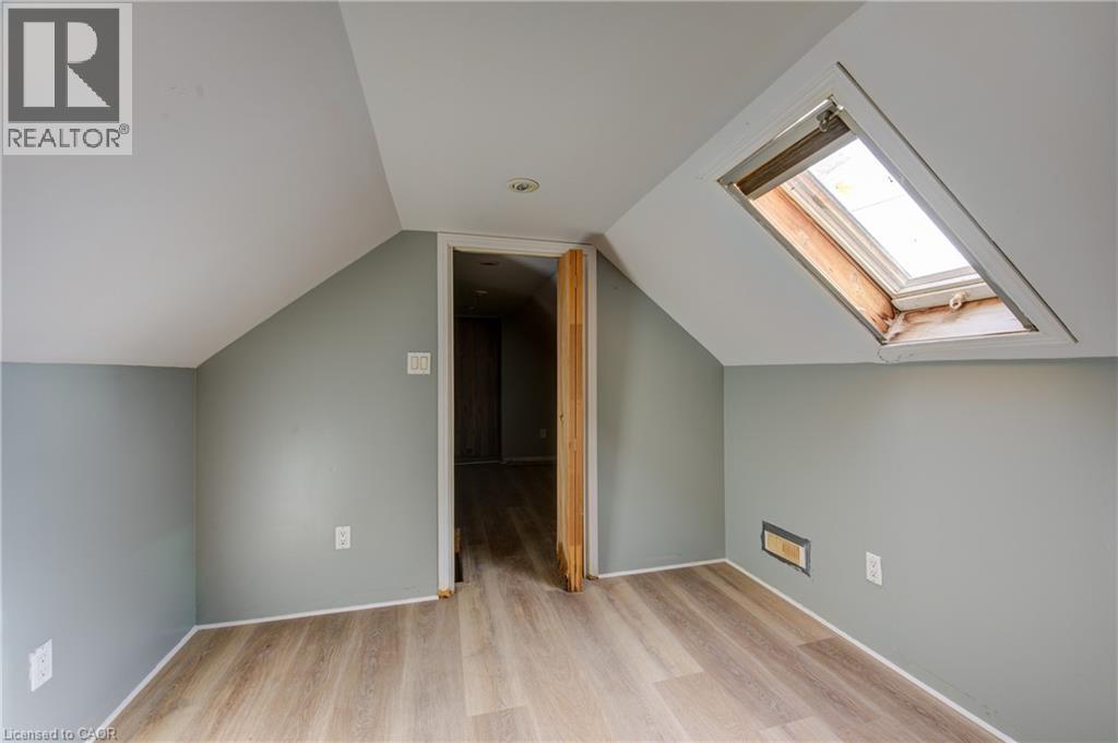 Bedroom 2 featuring a skylight, wood-finish flooring, recessed lighting, and sloped ceilings - 1 Rathgar Street, London, ON - Indoor Photo Showing Other Room