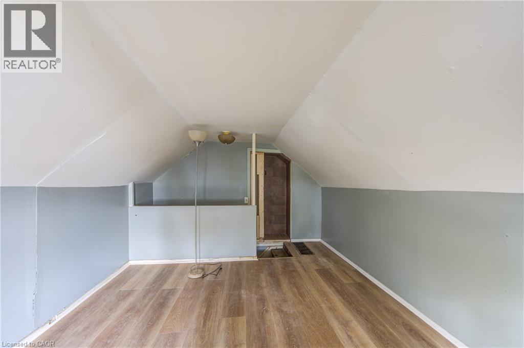 Bedroom 3 featuring wood-finish flooring, light gray and white painted walls, and a sloped ceiling - 1 Rathgar Street, London, ON - Indoor Photo Showing Other Room