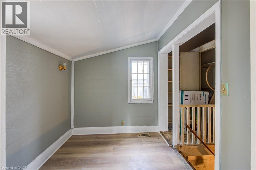 Access to basement stair hallway featuring wood-finish flooring, a single window with grilles, and light gray wall finishes - 1 Rathgar Street, London, ON - Indoor Photo Showing Other Room