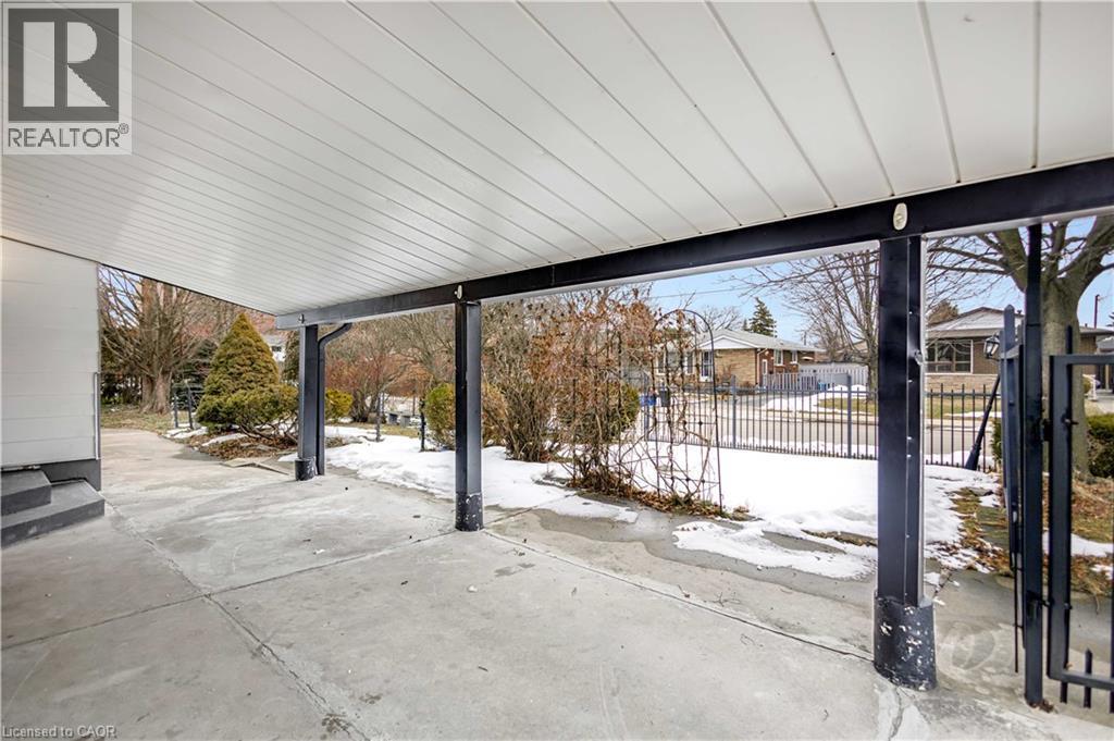 Covered concrete patio with a white paneled ceiling and black support beams - 85 Ranchdale Drive, Hamilton, ON - Outdoor
