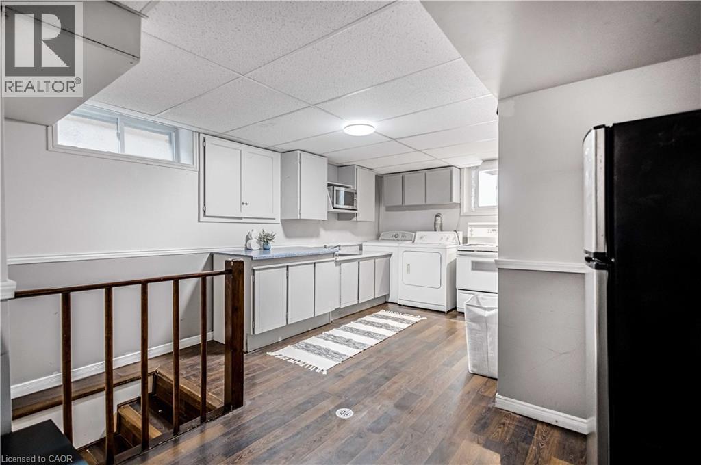 Lower level utility space featuring wood-finish flooring and a drop ceiling - 85 Ranchdale Drive, Hamilton, ON