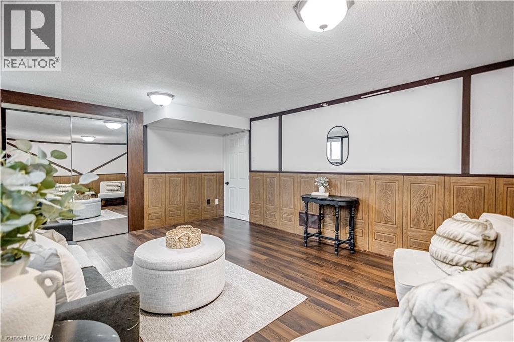 Wood-finish flooring throughout, complemented by paneling on the lower walls and painted white on the upper walls - 85 Ranchdale Drive, Hamilton, ON