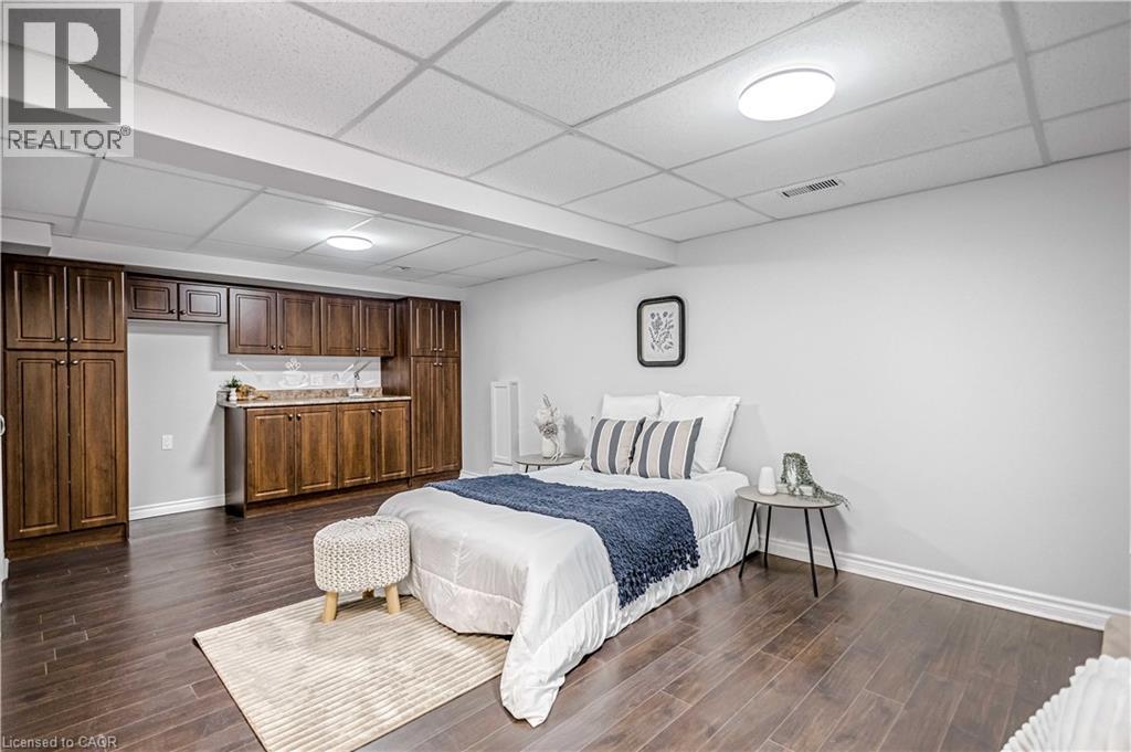 Wood-finish flooring throughout, complemented by a full wall of rich wood-tone cabinetry - 85 Ranchdale Drive, Hamilton, ON