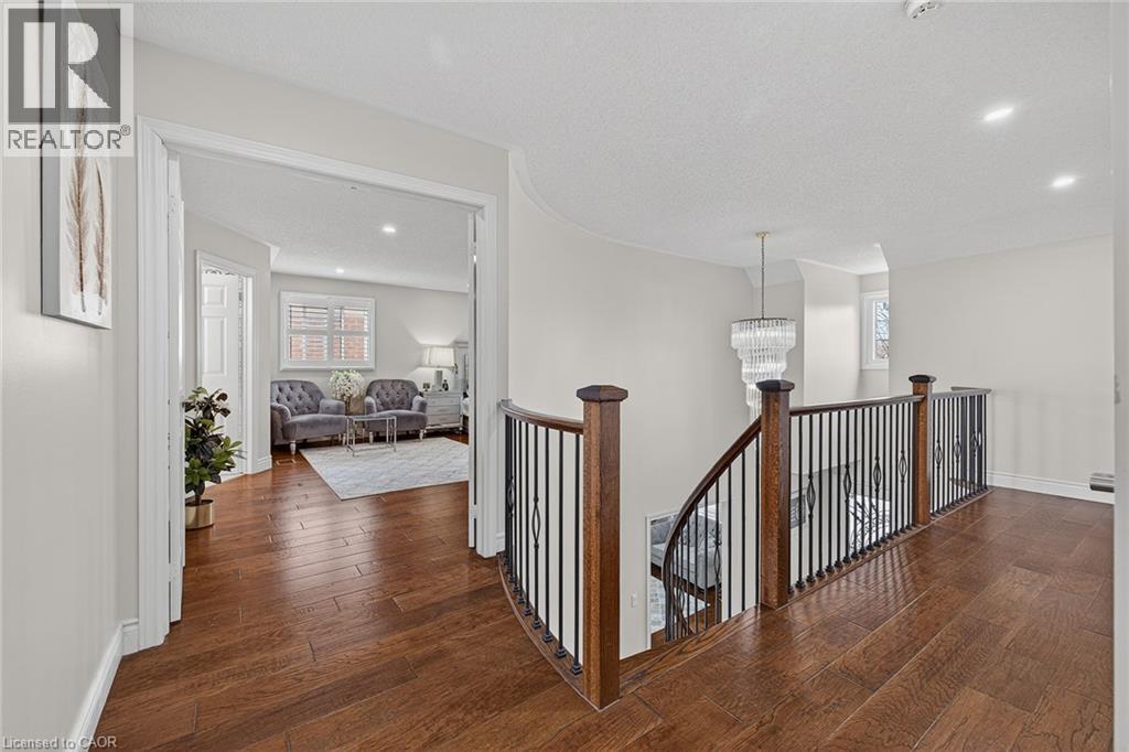 Curved staircase with wood-finish handrails and black metal balusters - 79 Holbrook Crescent, Cambridge, ON - Indoor Photo Showing Other Room