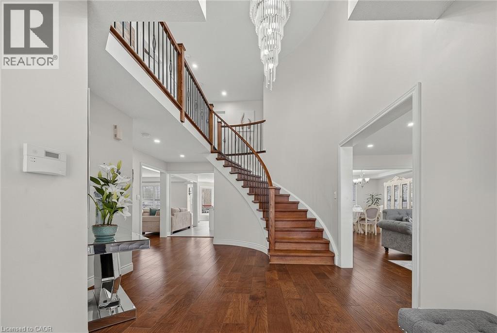 Grand foyer featuring a curved staircase with wood treads and wrought iron balusters - 79 Holbrook Crescent, Cambridge, ON - Indoor Photo Showing Other Room
