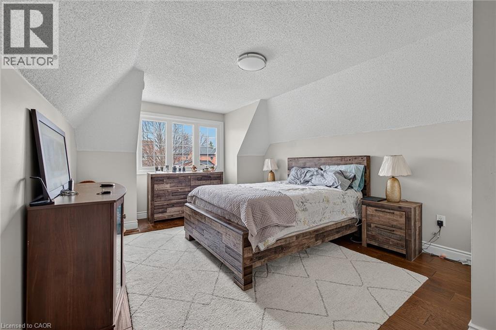 Hardwood flooring and light wall colors enhance this bedroom with sloped ceilings - 79 Holbrook Crescent, Cambridge, ON - Indoor Photo Showing Bedroom