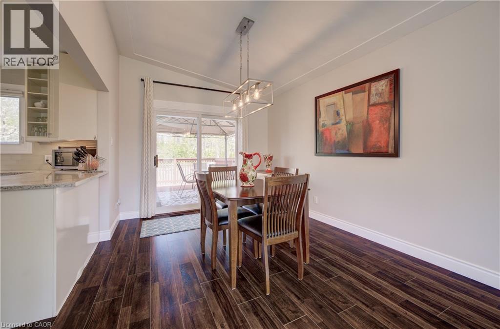 Dining area featuring wood-finish flooring, a contemporary linear chandelier, and a vaulted ceiling - 172 Rennie Drive, Kitchener, ON - Indoor Photo Showing Dining Room