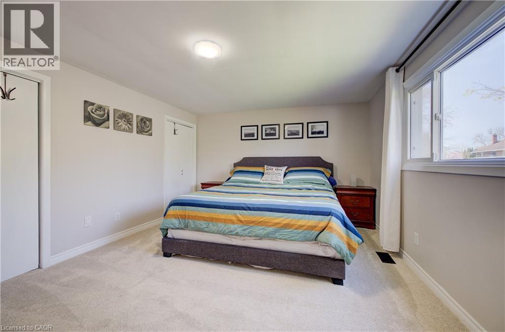 Carpeted room featuring a double-hung window, light-colored walls, and two white interior doors - 172 Rennie Drive, Kitchener, ON - Indoor Photo Showing Bedroom
